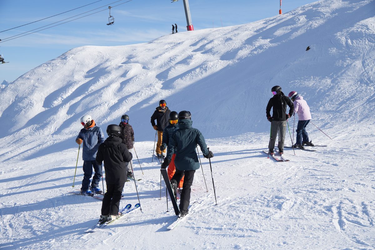 The trainee instructor cohort regrouping mid-lesson on the mountain